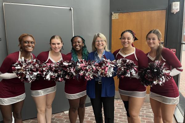 President Kornbluth (center) stands in the middle and poses with MIT cheerleaders on Demo Day.