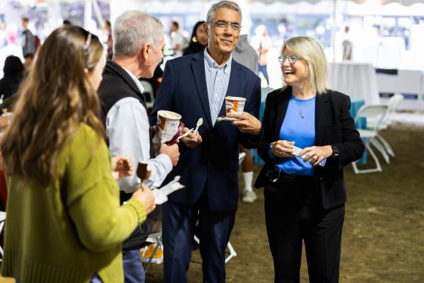 President Kornbluth on the far left smiles in a group at the MIT Ice Cream Social.